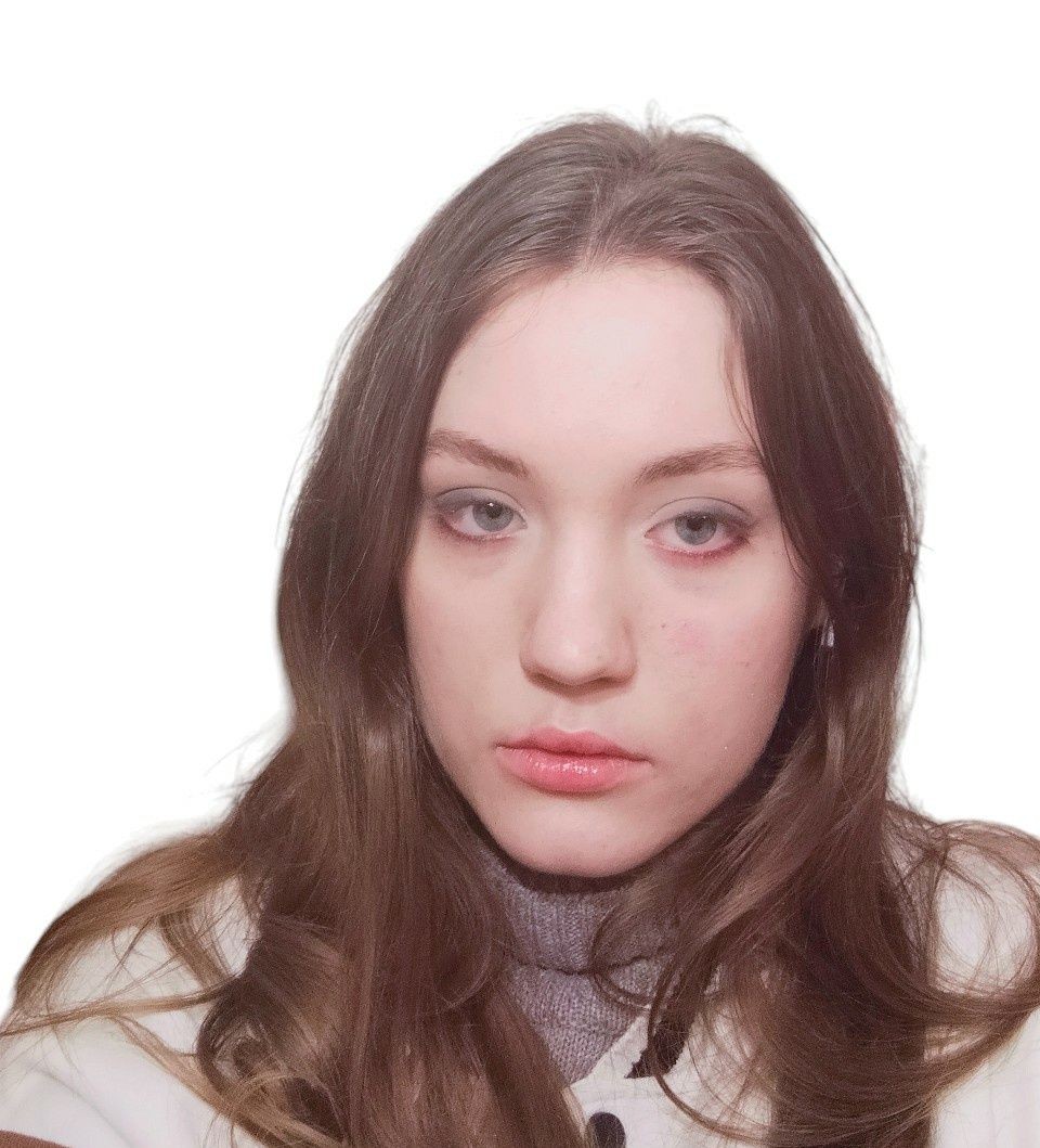 Portrait of a person with long brown hair and a neutral expression on a white background.